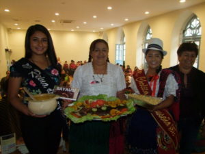La reina Karla Ruilova (1 izquieda) y la Cholita Sayausí, Estefanía Bermeo, junto a otros sayauseños, muestran varios platos, en los que resalta la trucha.(AZD) 