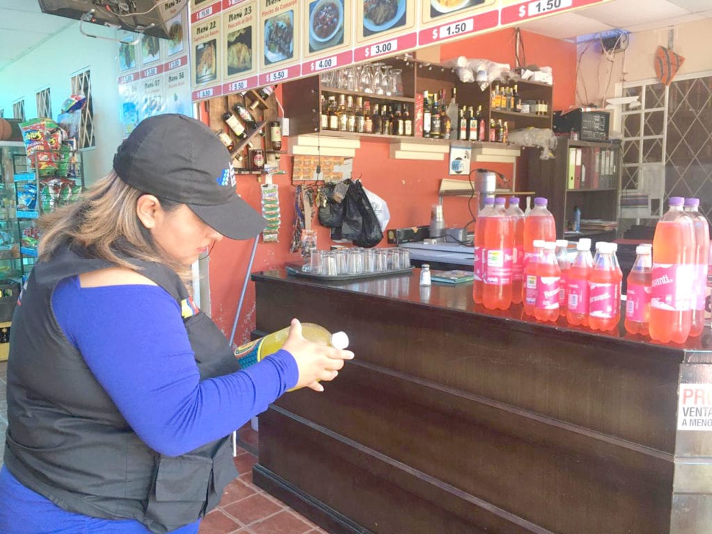 Una funcionaria de Arcsa, revisa las fechas de caducidad de los productos en un local de Paute. (Cortesía)