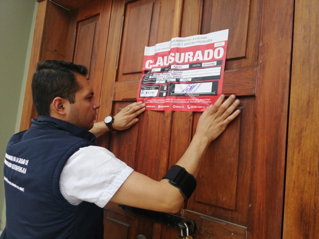 Un funcionario de la ACESS coloca el sello de clausura en el laboratorio que incumplió la normativa.(Cortesía)