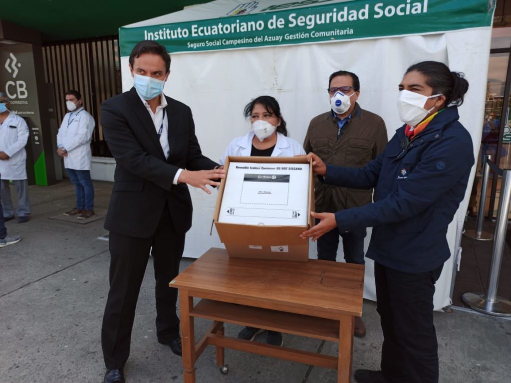 El prefecto del Azuay, Yaku Pérez (D), a la derecha, entrega los insumos para los pruebas COVID, a los directivos del IESS.(Cortesía)