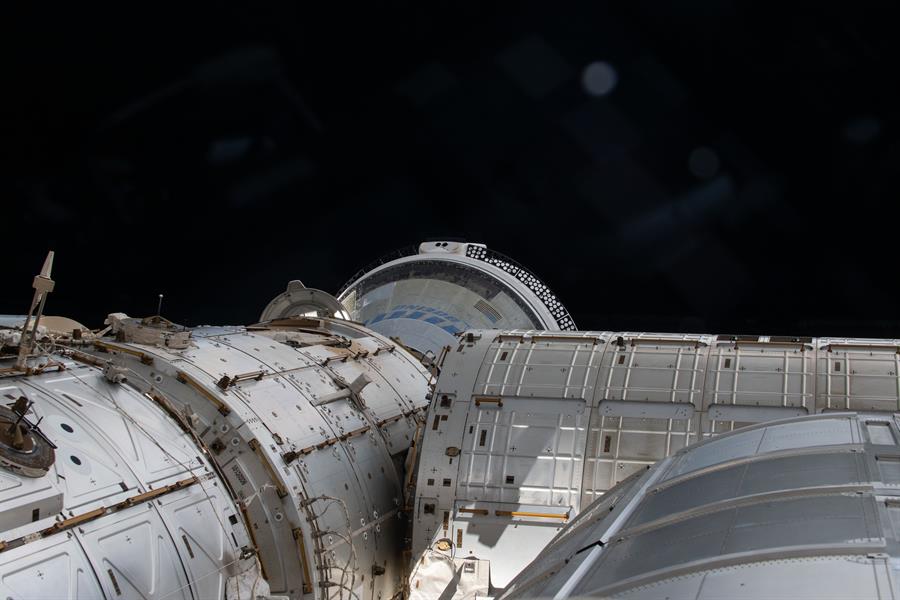 Fotografía cedida por la NASA de una instantánea tomada el día 6 de junio de 2024 desde una ventana donde se muestra en una parte el espacio y la nave espacial Starliner de Boeing atracada en el puerto delantero del módulo Harmony en la Estación Espacial Internacional (EEI). La primera misión espacial tripulada de la empresa Boeing, que llegó el pasado 6 de junio a la Estación Espacial Internacional (EEI), ha retrasado cuatro días su regreso a la Tierra, que estaba previsto para mañana viernes, debido a filtraciones de helio. EFE