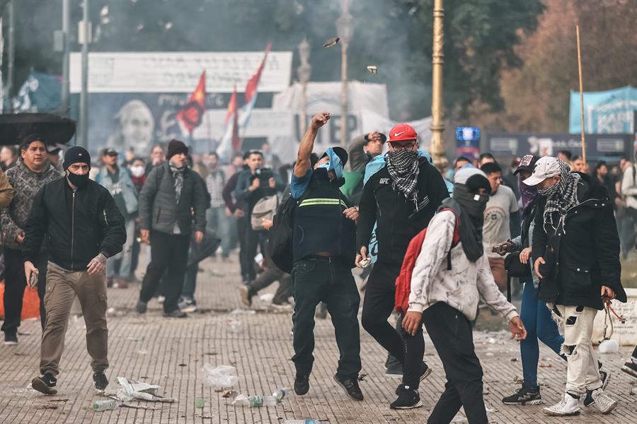 Personas protestan a las afueras del senado durante un debate este miércoles, en Buenos Aires (Argentina). Manifestantes y policías protagonizan un choque este miércoles a las puertas del Senado de Argentina mientras la cámara legislativa debate la ley de Bases, el proyecto estrella del Gobierno, con el que el presidente Javier Milei pretende implementar un paquete de reformas económicas de gran calado. EFE