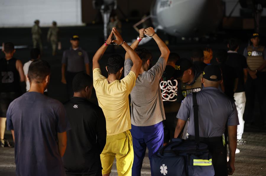 Migrantes esperan frente a un avión para ser deportados a Colombia este martes, en el aeropuerto Marcos A. Gelabert en Ciudad de Panamá (Panamá). El primer vuelo de retorno de migrantes irregulares que cruzaron la peligrosa selva del Darién, financiado por Estados Unidos en el marco de un acuerdo con Panamá, salió este martes de la capital del país centroamericano con destino a la ciudad de Medellín, en Colombia. EFE