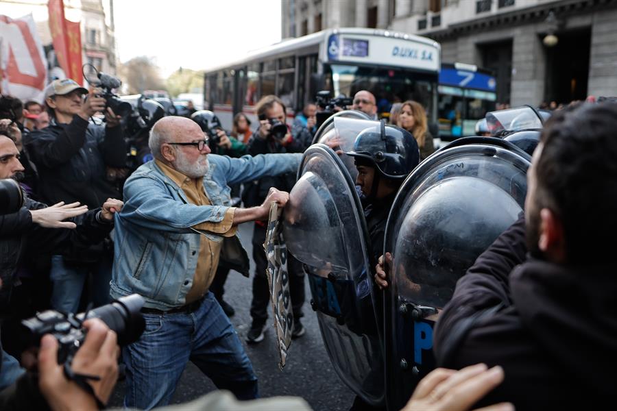 iembros de la Policía Federal Argentina (PFA) se enfrentan con manifestantes este miércoles, en Buenos Aires (Argentina). Colectivos de jubilados marchan desde el Congreso hacia la Plaza de Mayo de Buenos Aires para protestar contra el veto anunciado por parte del presidente, Javier Milei, a un aumento en las pensiones aprobado la semana pasada por el Senado. EFE