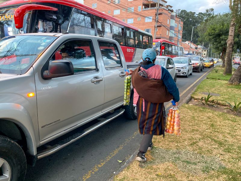 Una mujer vende frutas en una calle de Cuenca.